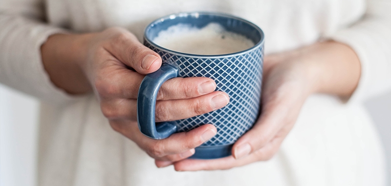Persoon houdt een koffiemok vast Persoon houdt een koffiemok vast