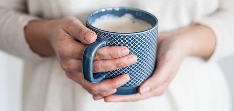 Persoon houdt een koffiemok vast